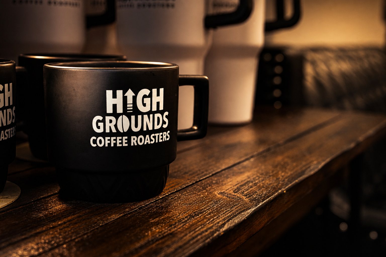 Black High Grounds Coffee Roasters ceramic mug on a wood table