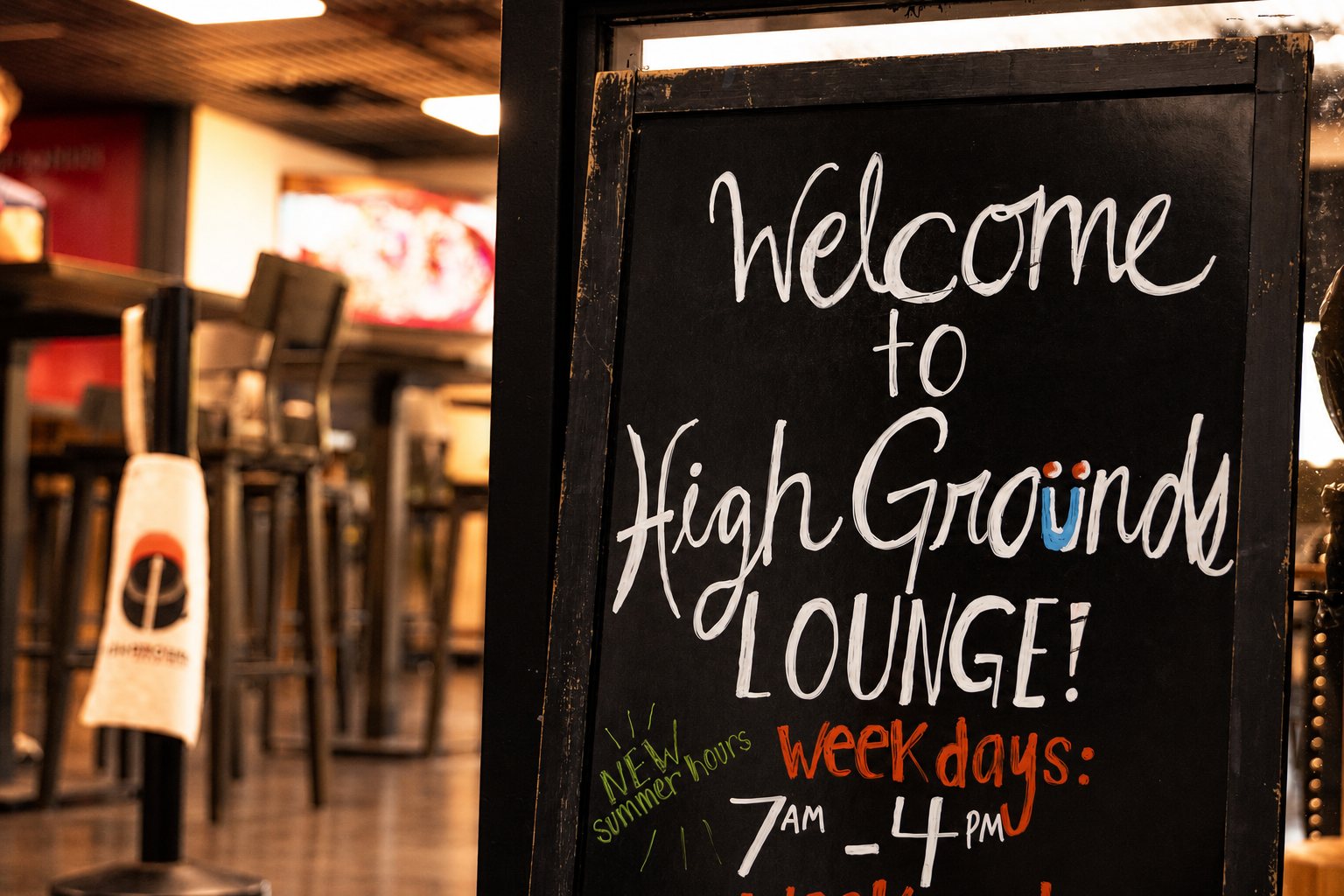 Hand-lettered chalkboard welcoming guests to High Grounds Lounge